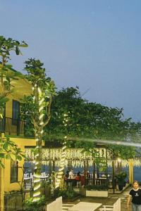 ein Gebäude mit einem Baum mit Licht in der Unterkunft Luti Homestay and Restaurant in Dong Hoi
