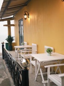 eine Gruppe von Tischen und Stühlen auf einer Terrasse in der Unterkunft Luti Homestay and Restaurant in Dong Hoi
