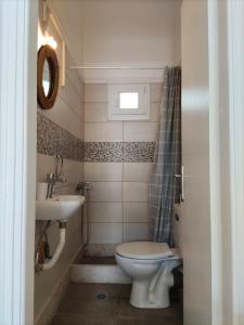 a bathroom with a toilet and a sink at Sunlit Shores Apartment in Loutra Killinis