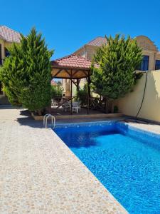 een zwembad voor een huis met bomen bij Villa in Baku in Baku