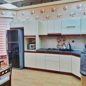 een keuken met witte kasten en een koelkast bij Villa in Baku in Baku