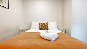 1 dormitorio con 1 cama con 2 toallas en Sky Stars Essential Home, en Auckland