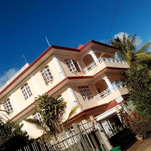 a large white building with a fence in front of it at Tonishka Villa in Trou aux Biches