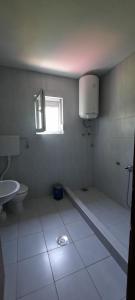 baño con aseo y lavabo y ventana en Guest House Đurmani, en Čanj
