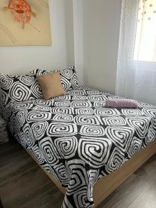 1 cama con edredón blanco y negro en un dormitorio en Royal Family Apartment, en Chirivella