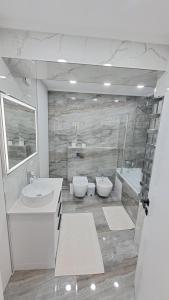ein Badezimmer mit 2 Waschbecken und 2 WCs in der Unterkunft Аэропорт Апартаменты 24&24 Parking in Chişinău
