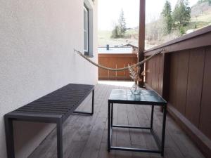 uma varanda com um banco, uma mesa e uma janela em Leni`s Mountain Appartements em Dienten am Hochkönig