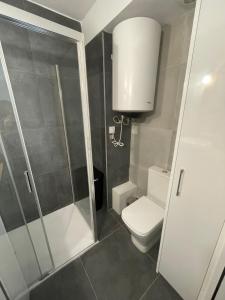 a small bathroom with a toilet and a shower at Monte y mar Albufereta in Alicante +5 photos