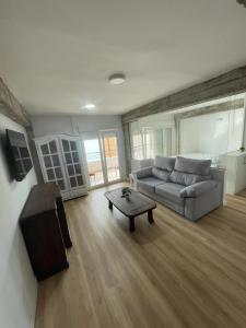 uma sala de estar com um sofá e uma mesa de centro em Monte y mar Albufereta em Alicante
