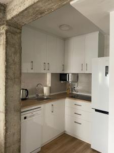 uma cozinha com armários brancos e electrodomésticos brancos em Monte y mar Albufereta em Alicante