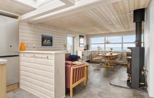 2 Bedroom Beach Front Home In Otterup في Otterup: مطبخ مع موقد وغرفة طعام مع طاولة