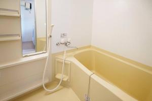 a bath tub with a hose in a bathroom at 1日1組限定 北海道最古の写真館 2台無料駐車場 in Hakodate +21 photos