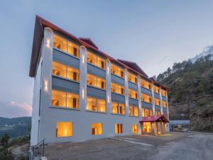 a large white building with its lights on at Kavin - The Chail Resort in Chail