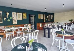 uma sala de jantar com mesas e cadeiras brancas em Brenaissance Wine & Stud Estate em Stellenbosch