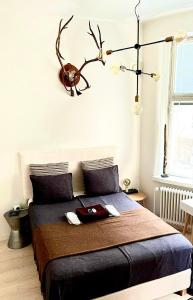 ein Schlafzimmer mit einem Bett mit einem Geweih an der Wand in der Unterkunft Art Nouveau - Jugend Talo in Helsinki Center Apartment in Helsinki