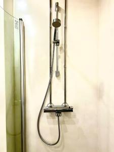a shower with a hose hanging on a wall at Art Nouveau - Jugend Talo in Helsinki Center Apartment in Helsinki