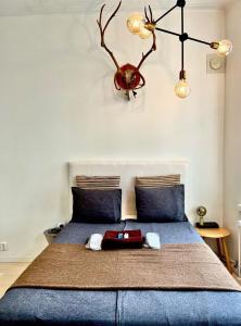 una camera da letto con un letto blu e un lampadario a braccio sopra di esso di Art Nouveau - Jugend Talo in Helsinki Center Apartment a Helsinki