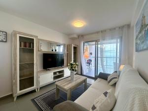 a living room with a white couch and a tv at Hipocampos in Calpe