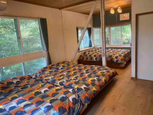 a bedroom with two beds in a room with windows at La Assayaca Nasu in Nasu-yumoto