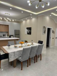 a dining room with a table and chairs and a kitchen at Gabala Villa Premium in Küsnǝt