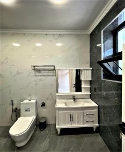 a white bathroom with a toilet and a sink at Gabala Villa Premium in Küsnǝt