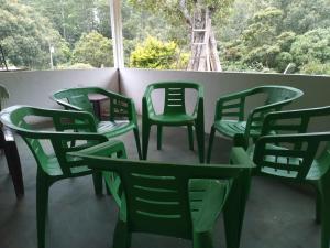 a group of green chairs sitting on a balcony at Horton Mountain in Ohiya