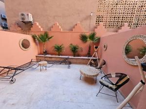 um pátio com cadeiras e mesas e um edifício em Charmant duplex au cœur de gueliz, quartier haut de gamme de Marrakech em Marrakech