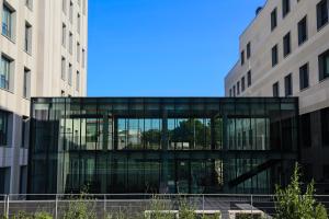 a glass building in front of two buildings at Apartamentos Turísticos UNEATLANTICO in Santander