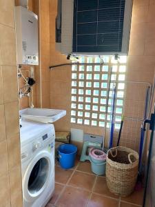 a bathroom with a washing machine and a sink at Bungalow house with views in Finestrat