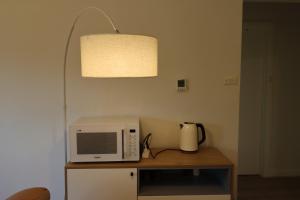 un microondas sobre una mesa con una lámpara en Humble Abode near Ringwood, en Heathmont