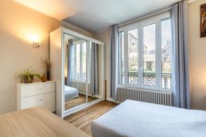 a bedroom with a bed and a large window at Superbe maison Familiale proche Paris La Défense in Nanterre