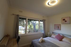 1 dormitorio con cama y ventana grande en Humble Abode near Ringwood, en Heathmont