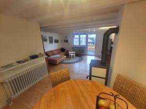 a living room with a table and a living room with a wood stove at Fichtenstüble in Todtmoos