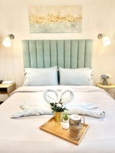 Una cama con dos toallas y una bandeja con dos corazones. en 119 Amani Grand Mactan Resort en Isla de Mactán