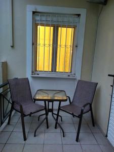 2 sillas y una mesa frente a una ventana en Κατάλυμα στην πόλη Χαλάνδρι, en Atenas