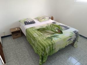 a bedroom with a bed with a green comforter at Maison Cécilia vue sur les saintes in Trois-Rivières