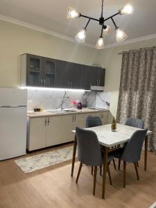 een keuken met een tafel en stoelen en een koelkast bij Villa VSV: Parking Spot+ View in Bathoria