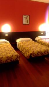 pokój hotelowy z 2 łóżkami i czerwoną ścianą w obiekcie Hotel motel residence Gonzaga w mieście Cantello
