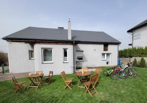 een tuin met tafels en stoelen en een huis bij Ogrodzieniec Pokoje 59 in Ogrodzieniec