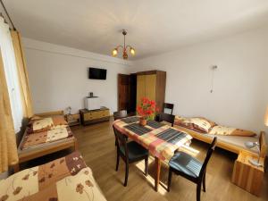 a room with two beds and a table and chairs at Ogrodzieniec Pokoje 59 in Ogrodzieniec