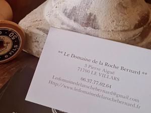 a piece of paper sitting next to a loaf of bread at Atypique Le Domaine de la Roche Bernard 