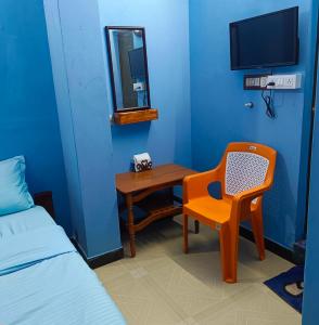 a room with a bed and a chair and a mirror at Blue Waves HomeStay in Pondicherry