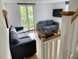 un soggiorno con divano e tavolo di Petite maison privative dans un environnement idyllique a Lasne