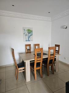 a dining room with a wooden table and chairs at Appartement de luxe in Cotonou