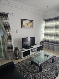 a living room with a tv and a coffee table at Appartement de luxe in Cotonou