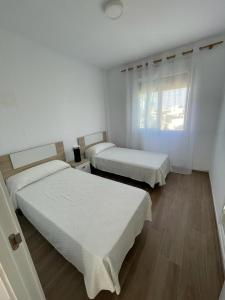 Zimmer mit 2 Betten und einem Fenster in der Unterkunft Apartamento cerca de la playa in Vinarós