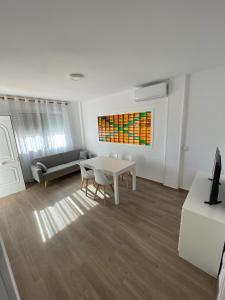 ein Wohnzimmer mit einem Tisch und einem Sofa in der Unterkunft Apartamento cerca de la playa in Vinarós