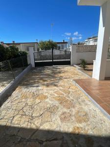 eine Terrasse mit Steinboden und einem Zaun in der Unterkunft Apartamento cerca de la playa in Vinarós