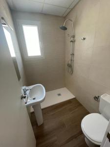 a bathroom with a sink and a toilet and a window at Apartamento cerca de la playa in Vinarós
