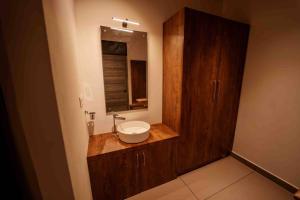 uma casa de banho com um lavatório e um espelho em Crocolakes huts BY Travellikee em Kenichira